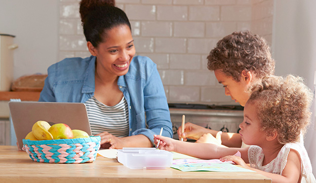 Vrouw met twee kinderen zittend aan een tafel