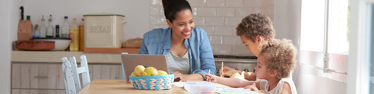 Vrouw met kinderen aan tafel in een huis