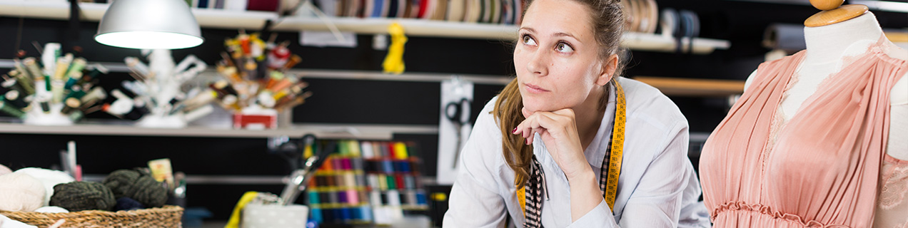 Vrouw leunend op werktafel met bedenkelijke blik